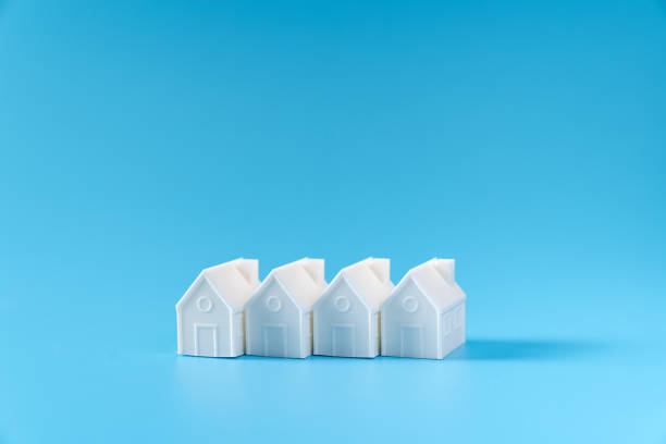 istock Miniature 3D printed model house on blue background 1748623148