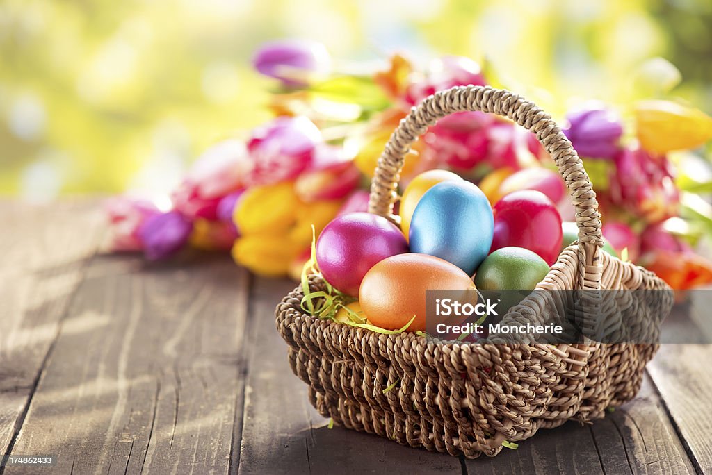 色のイースター卵、籐のバスケット、チューリップ - イースターエッグのロイヤリティフリーストックフォト
