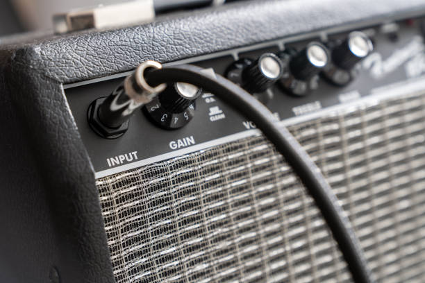 Close up of electric guitar amplifier Close up of electric guitar amplifier with a audio cable plugged into jack. Shallow depth of field amplifier plug stock pictures, royalty-free photos & images