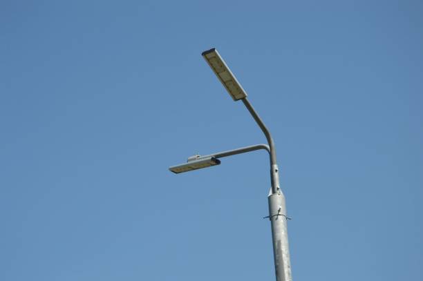 istock Public street lighting pole with two LED lights on a blue sky background. 1748625881