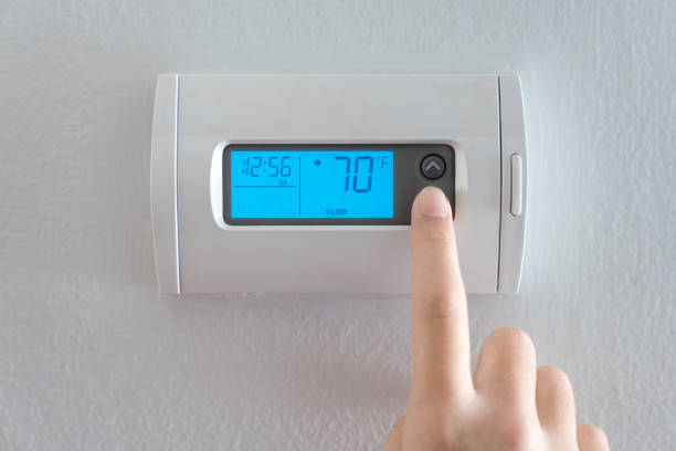 istock Hand press indoor room thermostat to lower the temp 1748626399