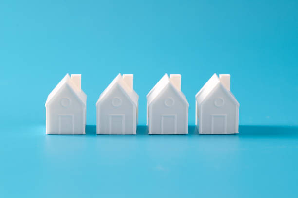 istock Miniature 3D printed model house on blue background 1748626927