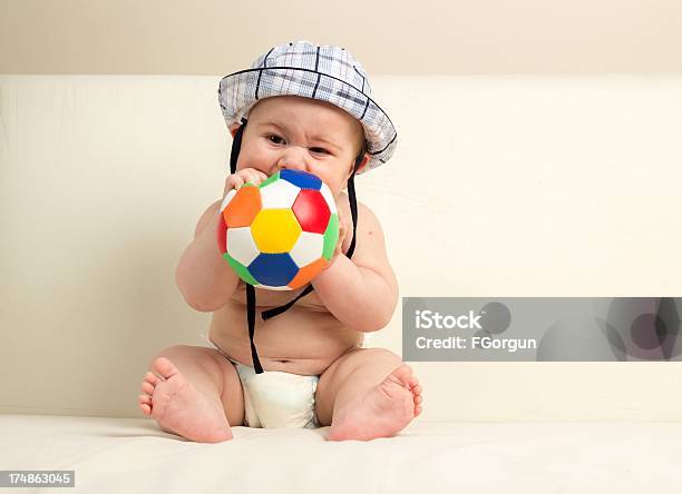 Carino Bambino Giocando Palla Mordere - Fotografie stock e altre immagini di 6-11 Mesi - 6-11 Mesi, Bebé, Cappello