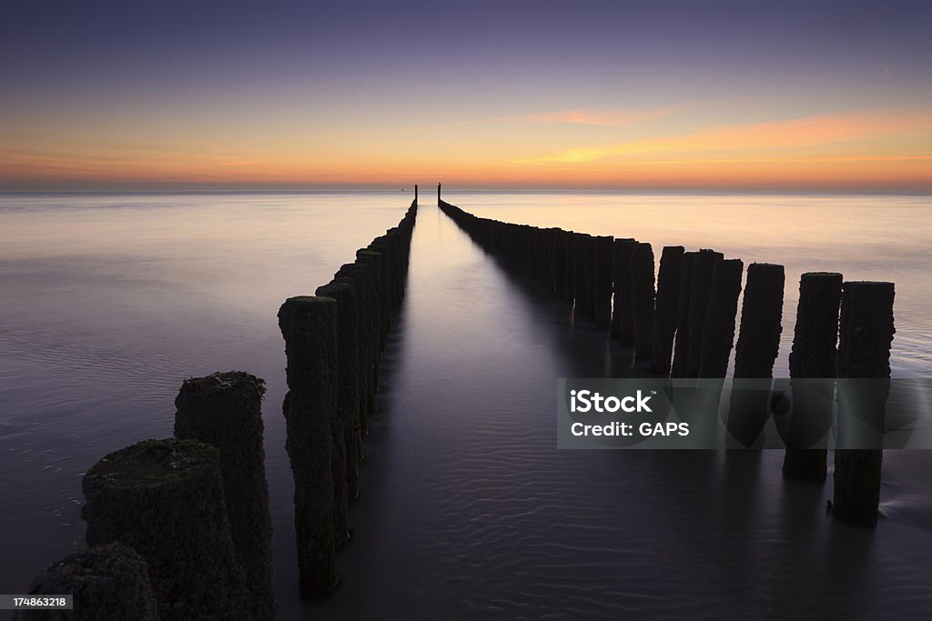 Wellen brechen auf einer hölzernen breakwater an der niederländischen Küste - Lizenzfrei Abenddämmerung Stock-Foto