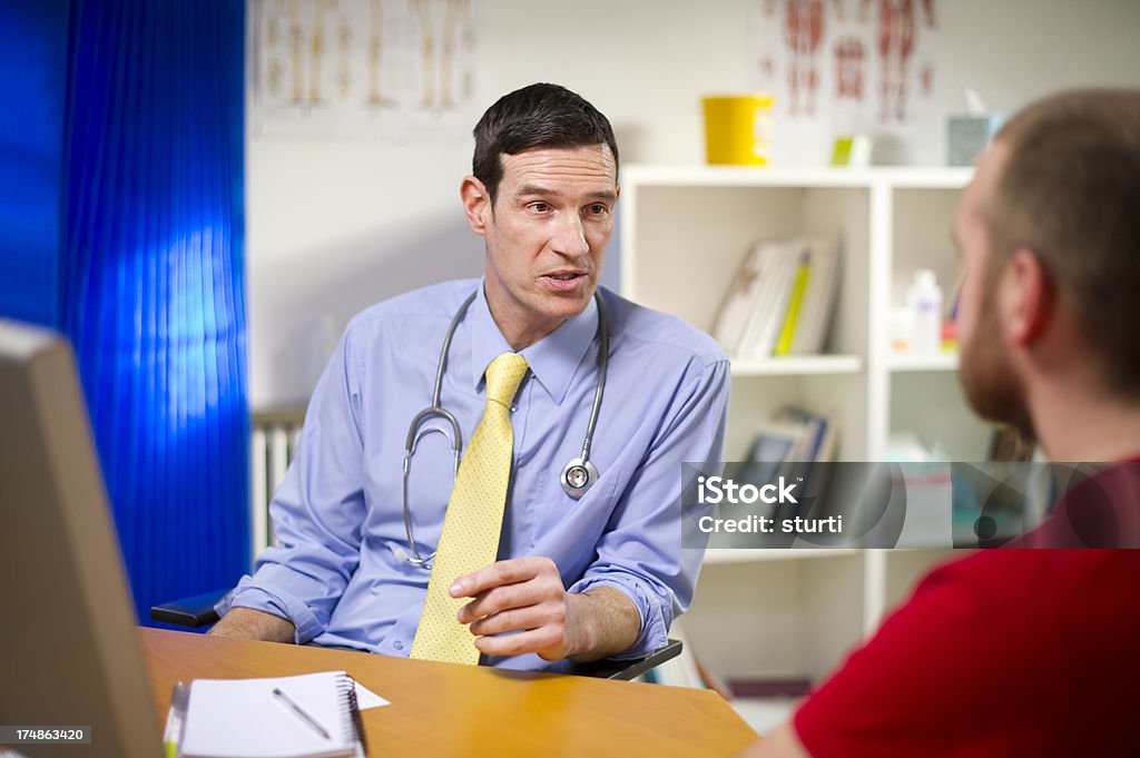 Lekarz rozmawia z mężczyzna pacjenta o mężczyzn rzeczy - Zbiór zdjęć royalty-free (20-29 lat)
