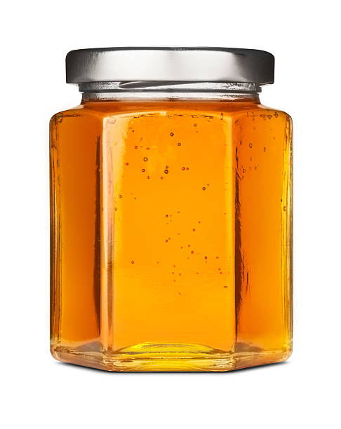 sechseckige jar of pure goldenen honig mit silberfarbener deckel - syrup jar sticky isolated objects stock-fotos und bilder