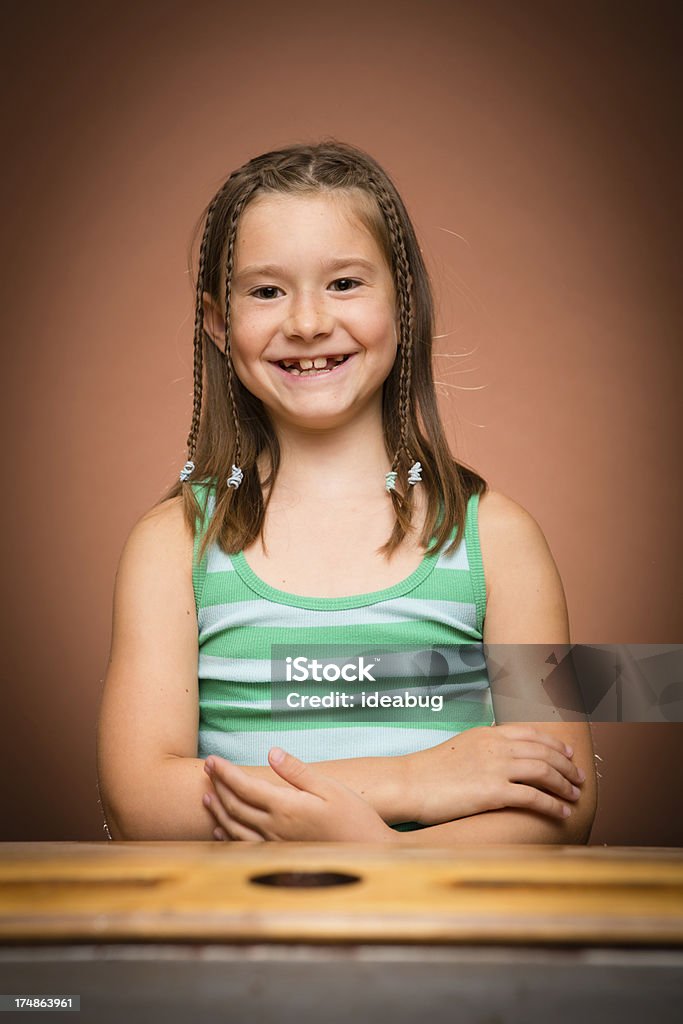 Восторге молодая девушка студент, сидя на школе стол - Стоковые фото 8-9 лет роялти-фри