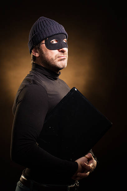 Portrait of Menacing Thief with Laptop Computer stock photo