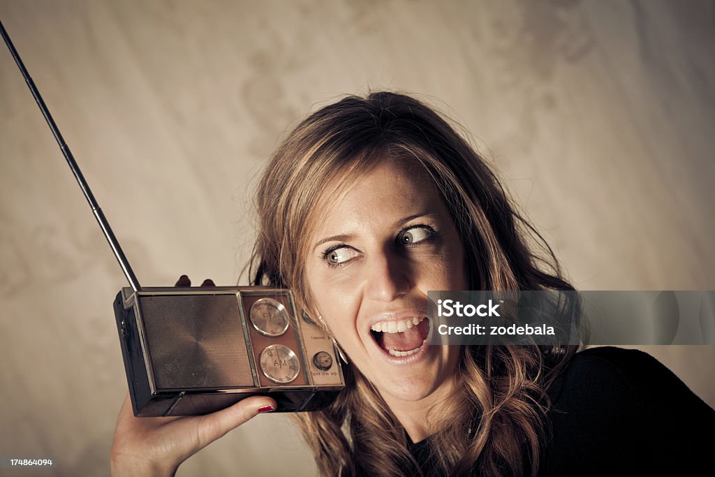 Bella bionda donna ascoltando musica su Vintage Radio - Foto stock royalty-free di Ascoltare