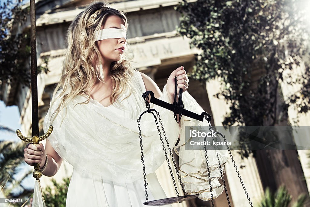 Lady Justice - Themis Portrait of the Themis/ Justitia - God of divine JusticeNotes: Sword and Scales are authentic antique pieces. Grain Added.Phrase on building behind is part of a generic latin proverb. 20-29 Years Stock Photo