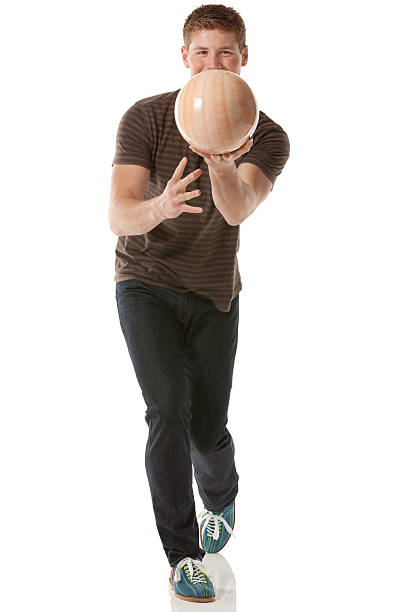 séduisante jeune homme jouant avec une boule de bowling - bowling isolated sportsman vertical photos et images de collection