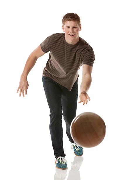 séduisante jeune homme jouant avec une boule de bowling - bowling isolated sportsman vertical photos et images de collection