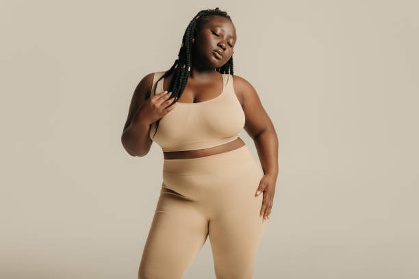 istock Attractive African plus size woman in underwear radiating self-love while standing on studio background 1748649952