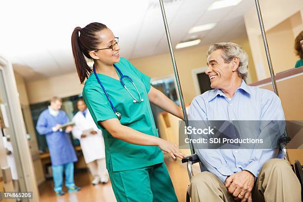 Старший Пациента Разговаривающего С Медсестрой В Больнице Прихожей Занятых — стоковые фотографии и другие картинки Активный пенсионер