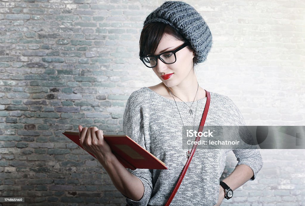 Moda studente o un docente la lettura di un libro - Foto stock royalty-free di Capelli castani