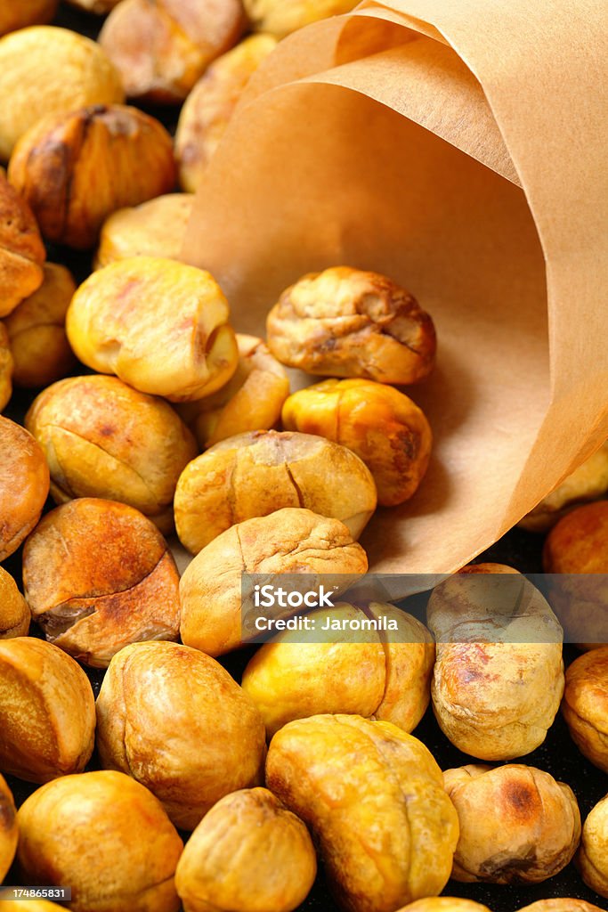 roasted chestnuts packing of roasted sweet chestnuts into a paper cornet Packing Stock Photo