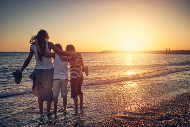 istock Kids enjoying beautiful sunset on the beach 1748659692