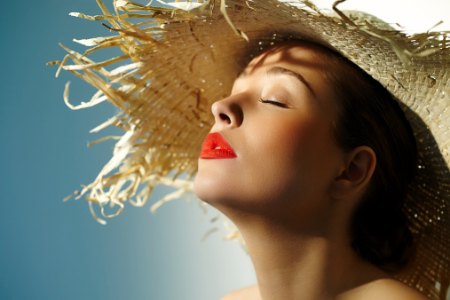 Woman wearing straw hat and enjoying the sun.