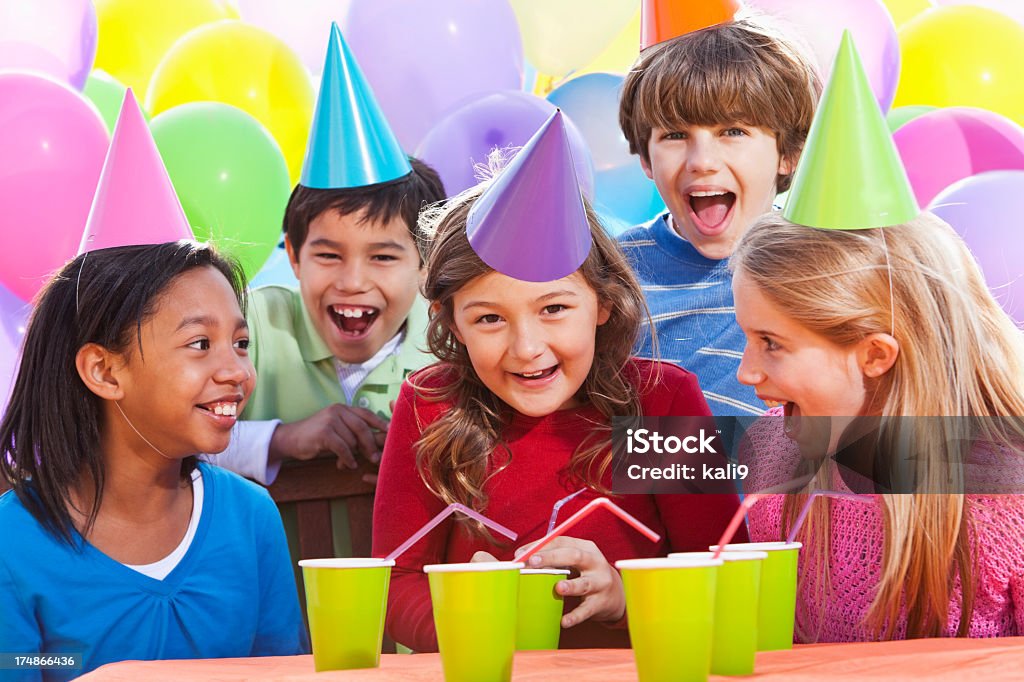 Children at birthday party Multi-ethnic children (7-10 years) having fun at birthday party.  (Hispanic boy, back left, is not in focus). Balloon Stock Photo