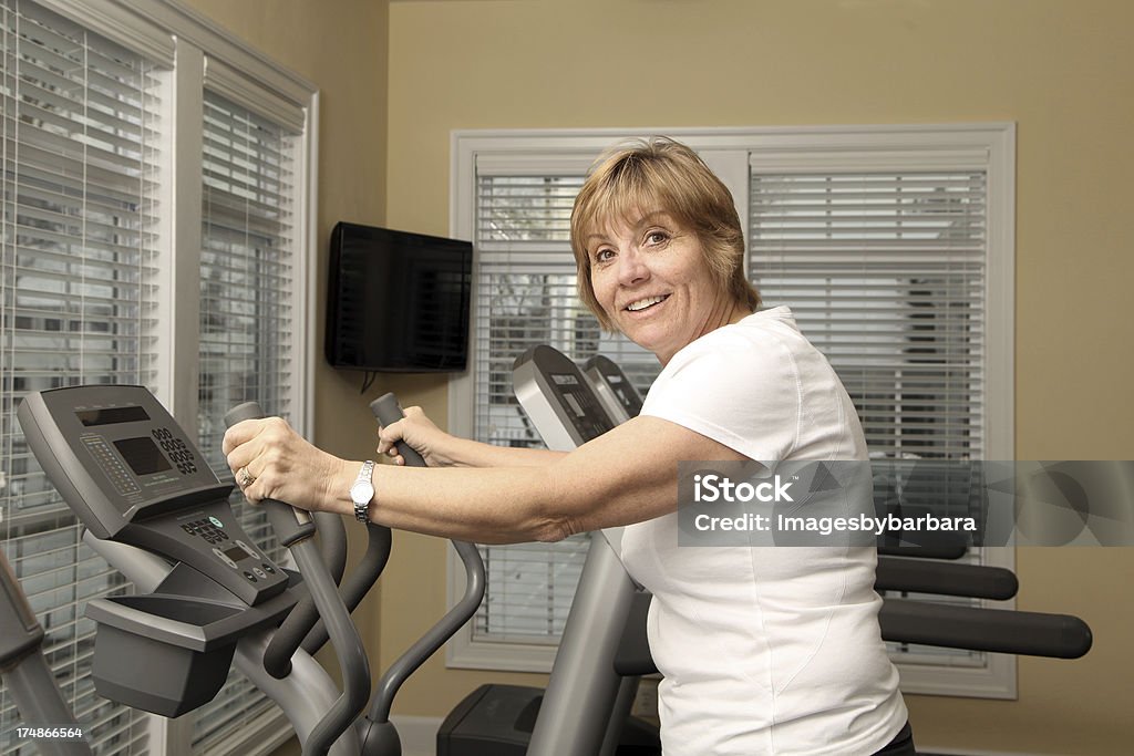 Mature Adult Exercising Mature adult using a stair stepper at a gym. One Woman Only Stock Photo