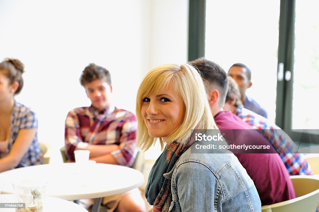 Studenti seduti in una caffetteria. - Foto stock royalty-free di Adulto