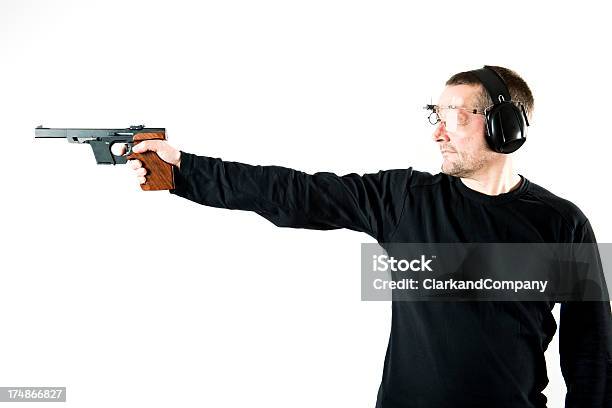 Hombre Que Agarra Pistola Y Practicar Tiro Foto de stock y más banco de imágenes de Arma de mano - Arma de mano, Tiro al blanco, Perfil - Vista de costado