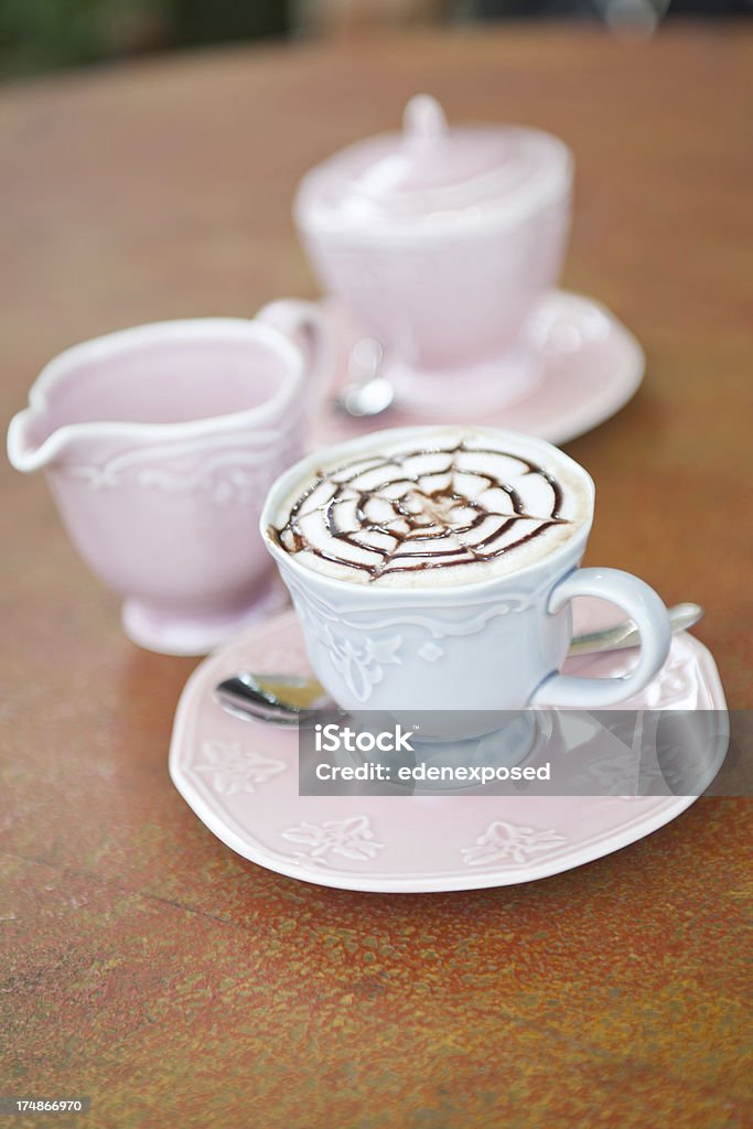 Mocha Coffee with Milk and Sugar A freshly made Mocha coffee on a saucer with a jug of milk and pot of sugar out of focus in the background.Vertical composition. Cafe Stock Photo