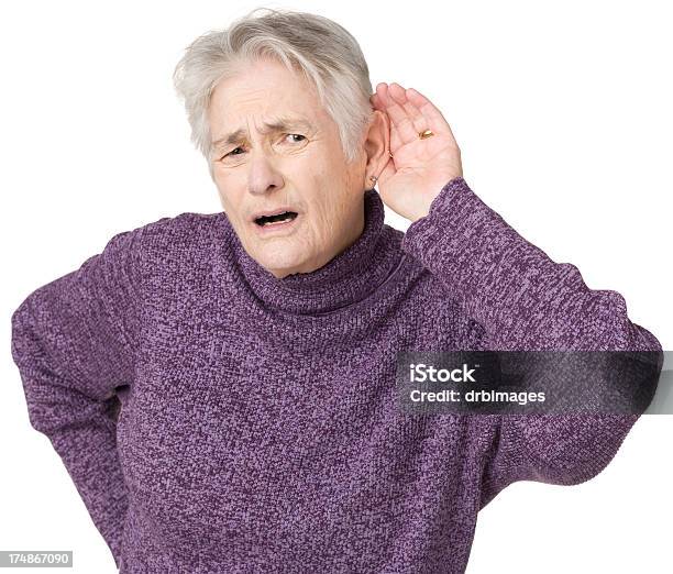 Senior Woman Listening With Hand To Ear Stock Photo - Download Image Now - Senior Women, Studio Shot, Suspicion