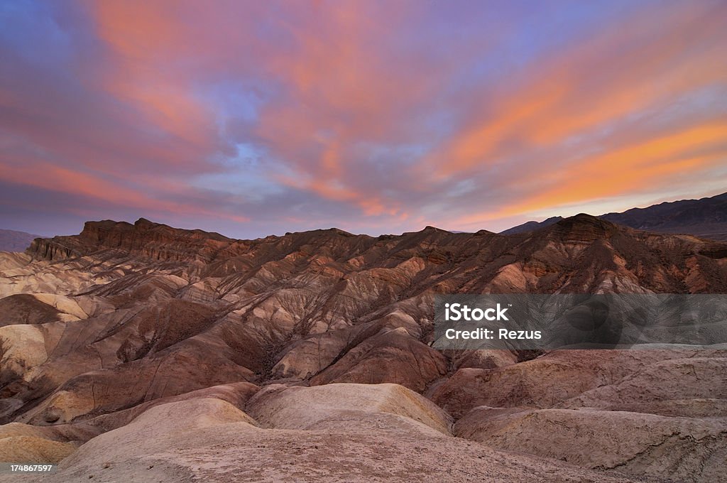 Paisaje de Zabriskie punto con un color rosa brillante cielo - Foto de stock de Parque Nacional Death Valley libre de derechos