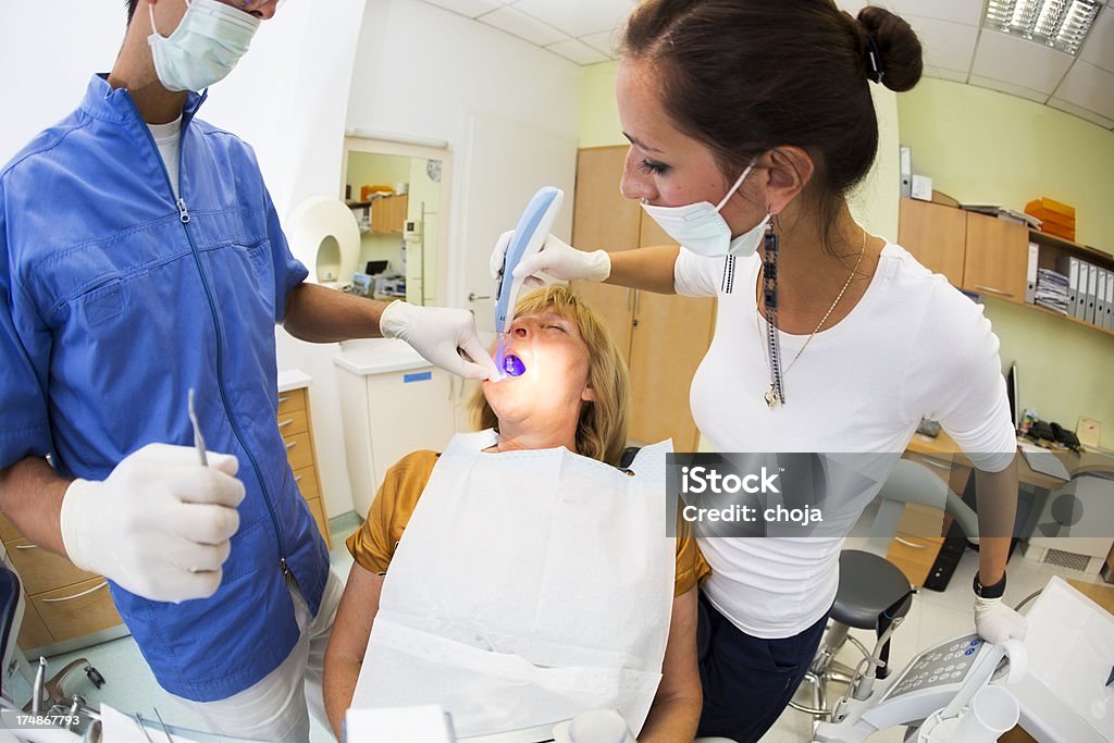 Meio envelhecido mulher no dentist.doctor e enfermeira trabalhando - Foto de stock de Adulto royalty-free