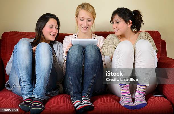 Foto de Jovem Mulher Usando Tablet Digital No Sofà e mais fotos de stock de Aconchegante - Aconchegante, Adolescente, Adolescentes Meninas