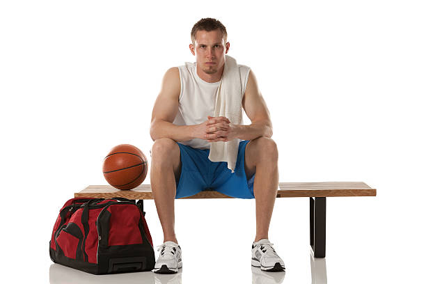 joueur de basket-ball assise sur un banc - shorts clothing sport sports clothing photos et images de collection