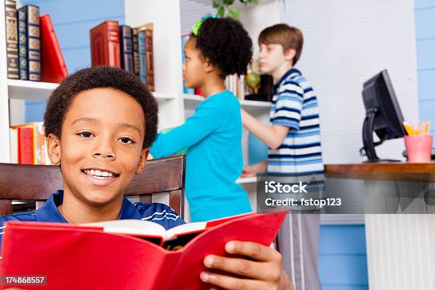 Multi Étnica Alunos A Ler Livros Na Biblioteca - Fotografias de stock e mais imagens de 10-11 Anos - 10-11 Anos, 12-13 Anos, Aluna