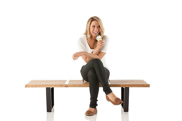 istock Smiling woman sitting on a bench with ice cream 174868896