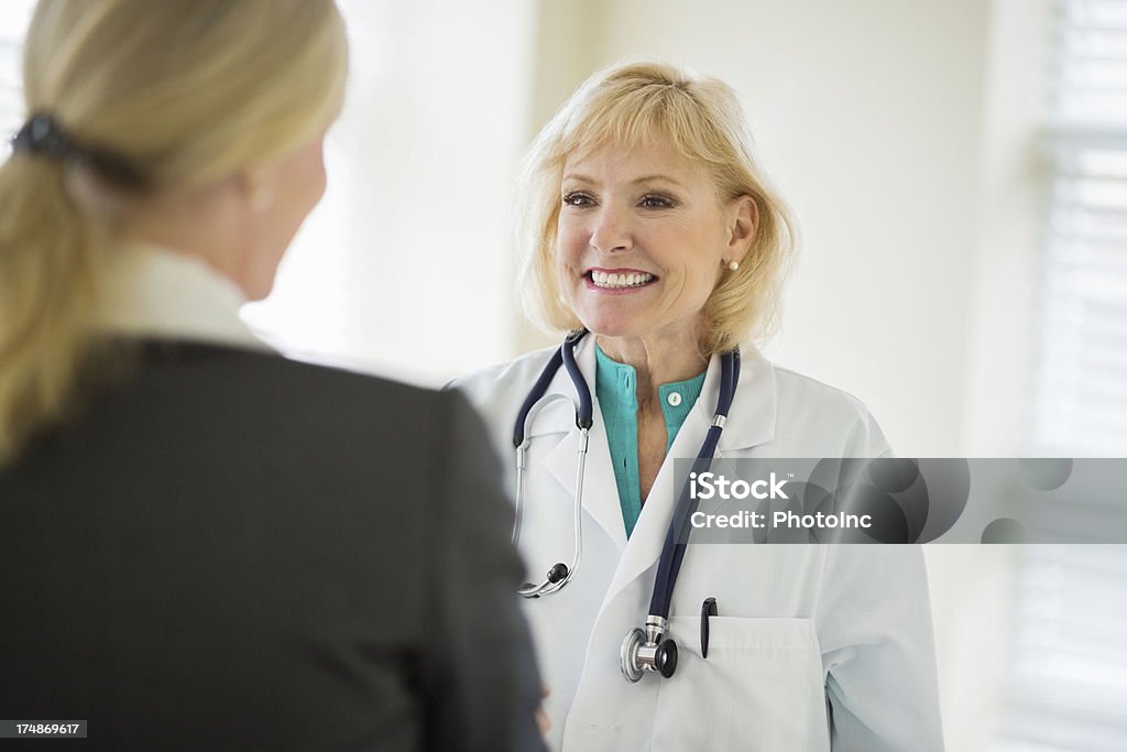 Enthousiaste médecin examinant Femme d'affaires - Photo de Cadre d'entreprise libre de droits