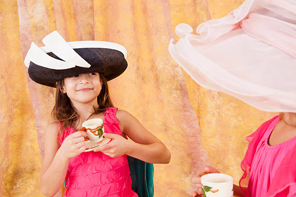 dos niños caucásicos niñas 7-8, juegan sombreros teacup - tea party dressing up little girls hat fotografías e imágenes de stock