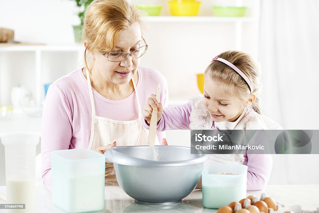 Starsza kobieta i dziewczynka w kuchni. - Zbiór zdjęć royalty-free (4 - 5 lat)