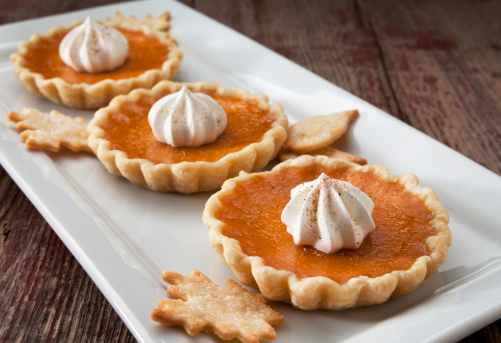 Pumpkin Tarts with whipped cream on a rustic background.