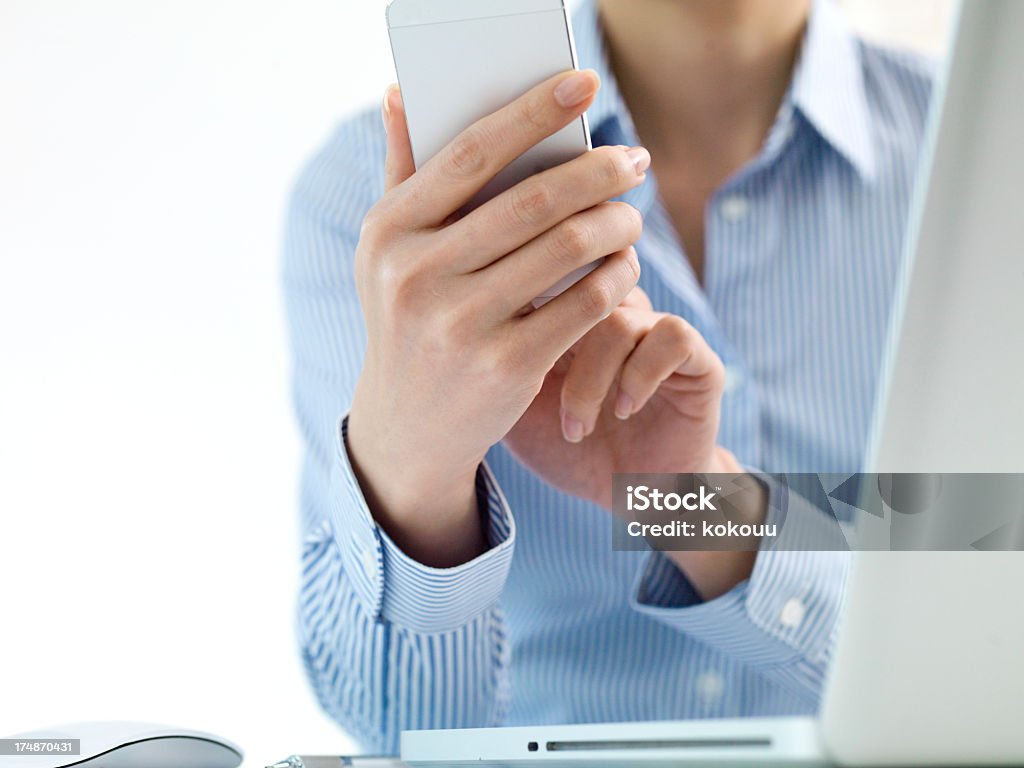 Mujer con un smartphone en la parte frontal detalles de PC portátil - Foto de stock de Adulto libre de derechos