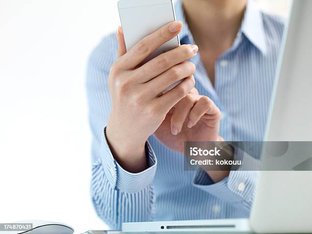 Mulher Que Toca Um Smartphone Na Frente Do Computador Portátil Pc - Fotografias de stock e mais imagens de Adulto