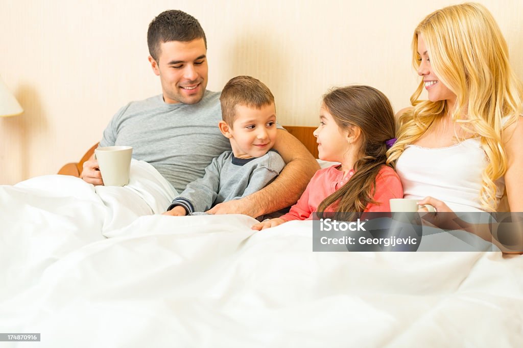 Семья, наслаждаясь вместе в постели - Стоковые фото 25-29 лет роялти-фри