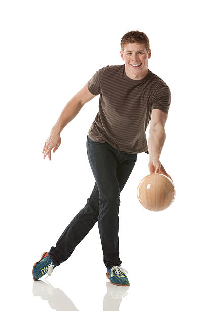 souriant jeune homme jouant avec une boule de bowling - bowling isolated sportsman vertical photos et images de collection