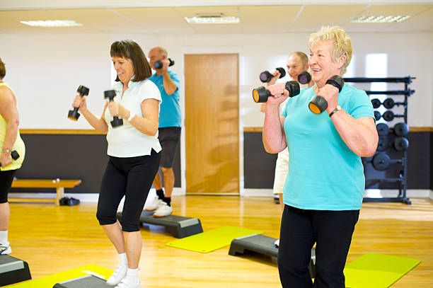 istock Senior people performing step aerobics in a gym 174871124