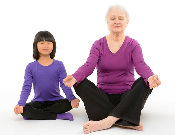 Girl and Senior Woman Practicing Yoga stock photo