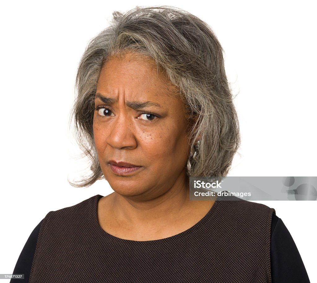 Judgemental Mature Woman Frowning At Camera Portrait of a mature woman on a white background. Women Stock Photo