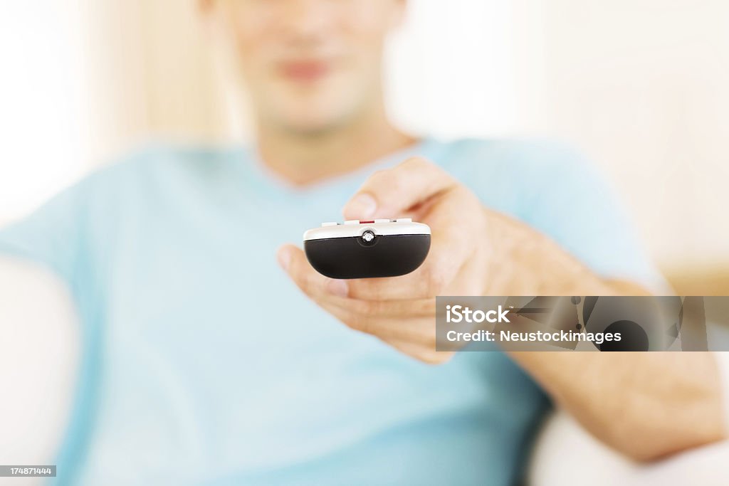 Young Man Holding Fernbedienung - Lizenzfrei Das Leben zu Hause Stock-Foto