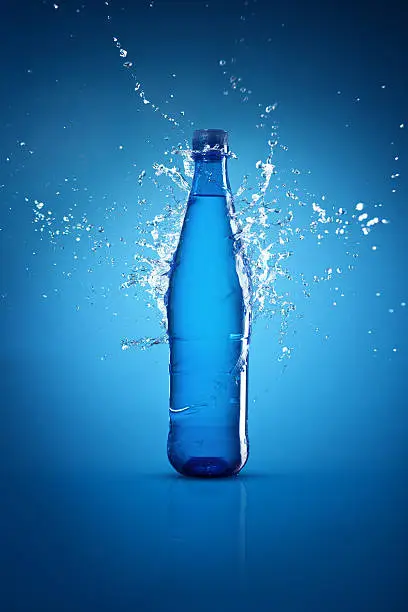 Water bottle on blue background and splash