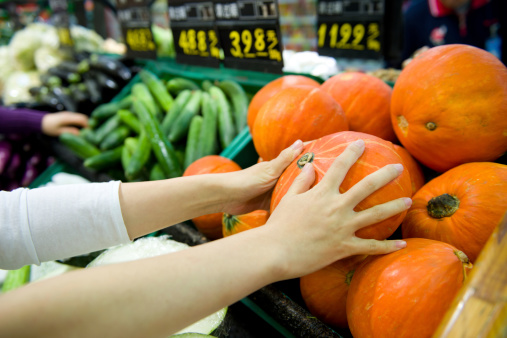 Woman  selecting vegetables from grocery store produce.