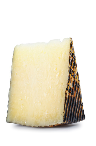 Slice of Manchego cheese isolated on white.