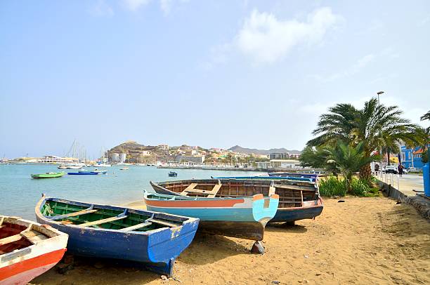 Mindelo Beached Rowboats A collection of fishing boats beached on Mabota Beach in Mindelo with more luxurious sailboats in the background porto grande stock pictures, royalty-free photos & images